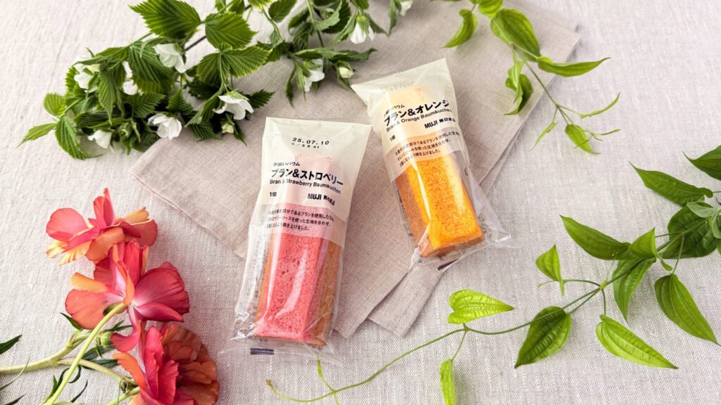 無印良品_「不揃いバウム ブラン＆ストロベリー」と「不揃いバウム ブラン＆オレンジ」のパッケージと植物が並んでいる様子