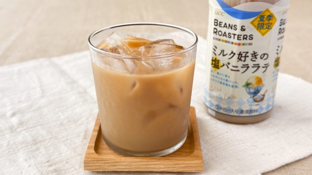 UCC_グラスに入った「UCC BEANS ROASTERS ミルク好きの塩バニララテ PET450ml」とペットボトルが並んでいる様子