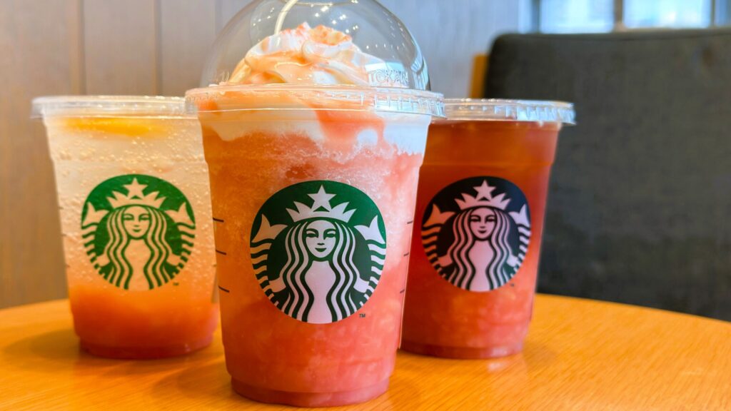 スターバックス_2025年夏ドリンク第4弾「ヘブンリー ピーチ フラペチーノ」「チラックス ソーダ ピーチ」「クラフト ジューシー ピーチ ティー」がテーブルの上に置いてある様子