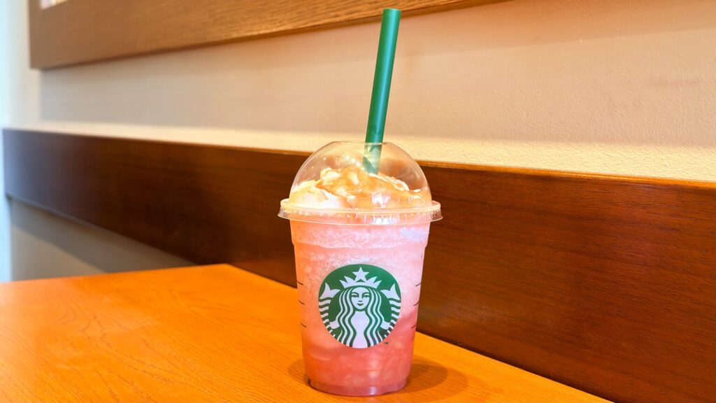 スターバックス_「More ヘブンリー ピーチ フラペチーノ®」にストローをさしている様子