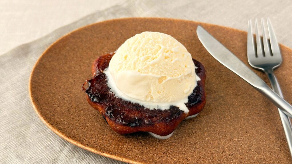 ミスタードーナツ_アイスクリームがのった「さつまいもド 香ばしブリュレ」とナイフ、フォークが並んでいる様子