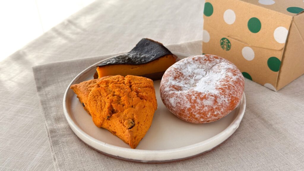 スターバックス_白皿に盛り付けた「スイートポテト マラサダ」や「パンプキンスコーン」、「パンプキンバスクチーズケーキ」