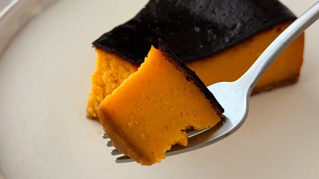 スターバックス_「パンプキンバスクチーズケーキ」をフォークで持っている様子