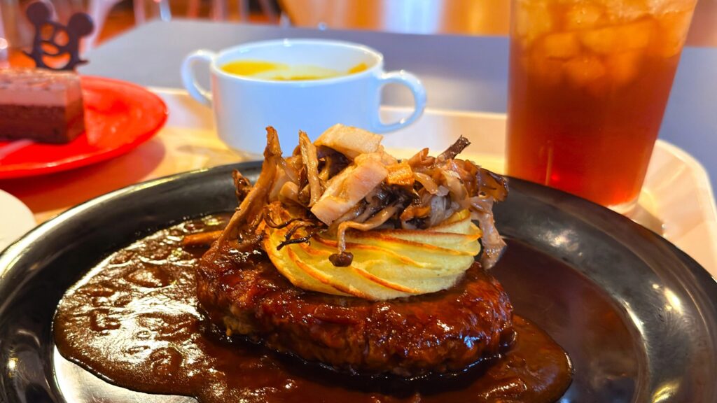 ディズニーシー_お盆にのったホライズンベイ・レストラン「スペシャルセット」ののハンバーグ、デミグラスオニオンソースやパンプキンクリームスープなどが並んでいる様子