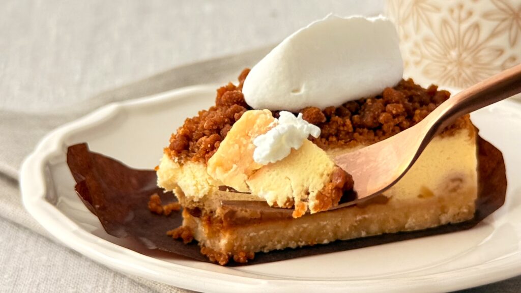 スターバックス_「ナッツ&キャラメルチーズケーキ」をフォークで持っている様子