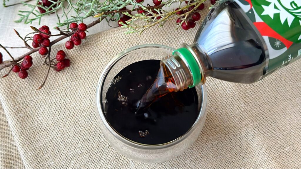 スターバックス_セブン-イレブン限定「スターバックス® GRAB&GOアイスド ブラック」をグラスに注いでいる様子