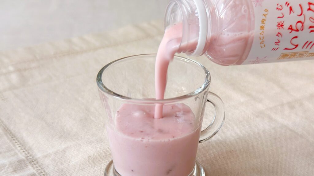 ファミリーマート_「ファミマの白をまとったいちご狩り®」の「ミルク楽しむいちごミルク」をグラスに注いでいる様子