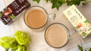 キッコーマン豆乳_グラスにはいった「クラフトソイ ソイラテ まろやかソイミルク」と「クラフトソイ ソイラテ ほろにがエスプレッソ」とパッケージがテーブルに置いてある様子