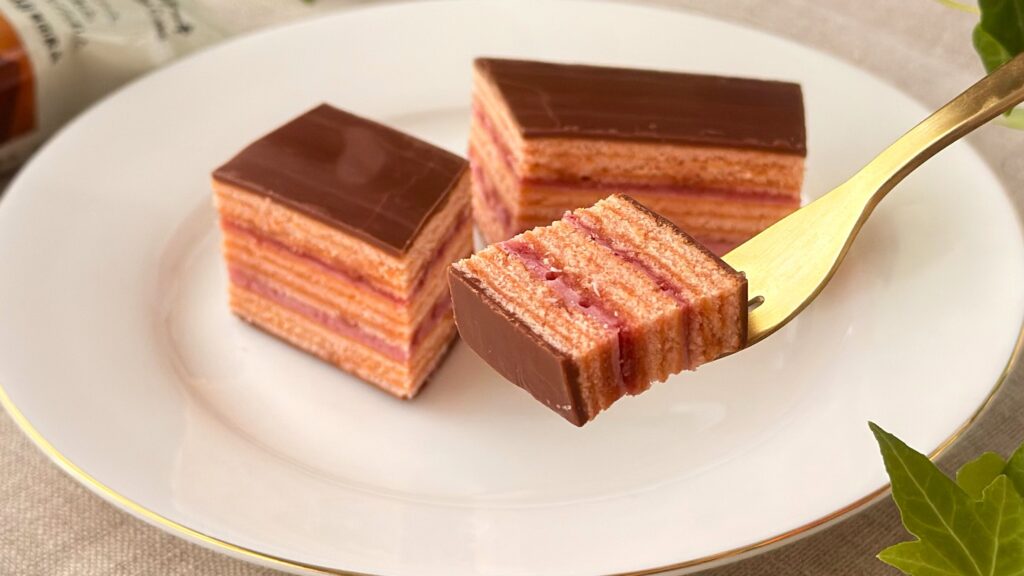 無印良品_「世界のお菓子 フランボワーズのオペラケーキ」をフォークで持っている様子