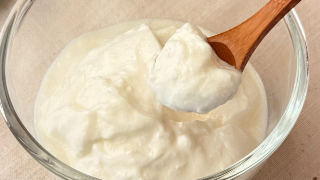 タカナシ乳業株式会社_ガラス皿によそった「北海道とろける生クリームヨーグルト」をスプーンですくっている様子