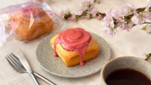カルディ_袋にはいった「シナモンロール 桜」や皿のせがテーブルに置いてある様子