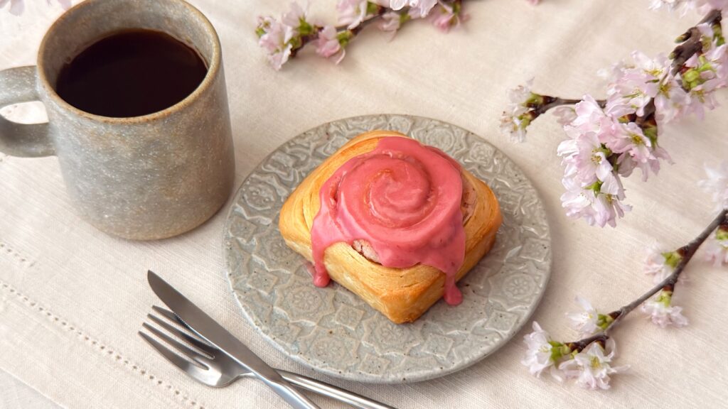 カルディ_「シナモンロール 桜」の皿のせとコーヒーが並んでいる様子