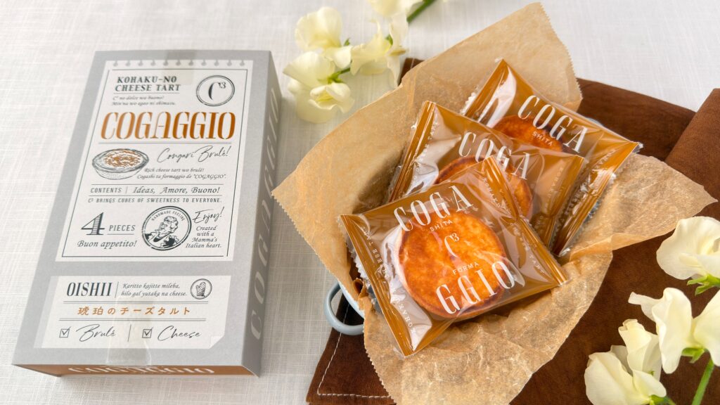 シーキューブ_「琥珀のチーズタルト コガッジオ」の個包装とパッケージが並んでいる様子