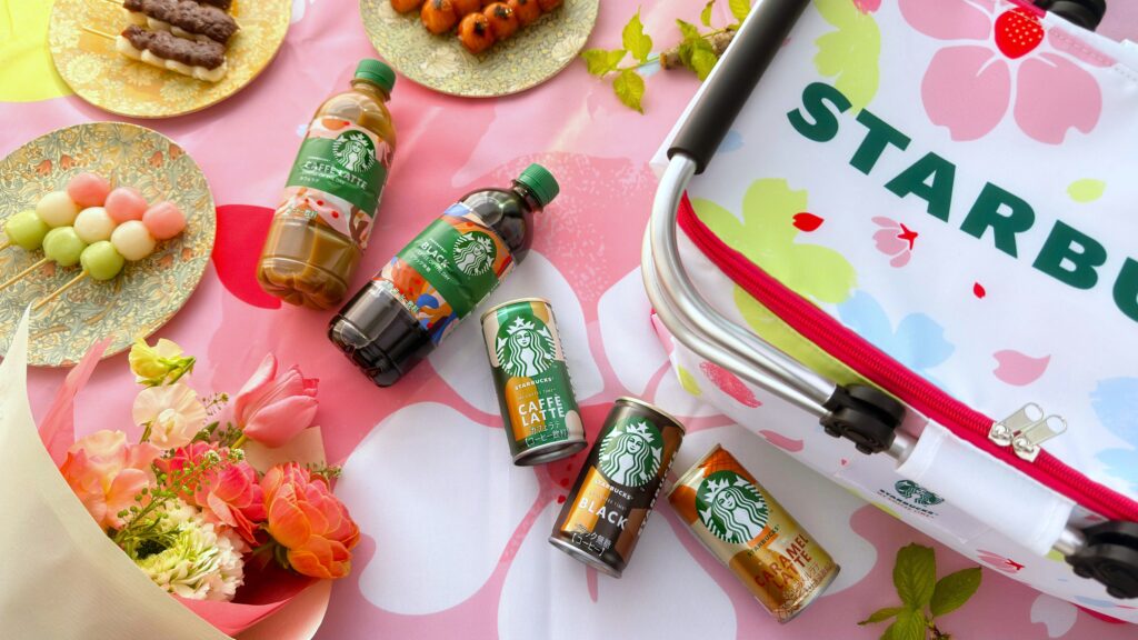 SAKURAキャンペーンの「スターバックスコーヒーオリジナル保冷バッグ」と「スターバックスオリジナルレジャーシート」、ペットボトルや缶コーヒーなどが置いてある様子SAKURAキャンペーンの「スターバックスコーヒーオリジナル保冷バッグ」と「スターバックスオリジナルレジャーシート」、ペットボトルや缶コーヒーなどが置いてある様子