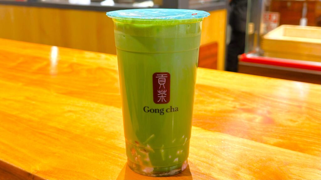 ゴンチャ_「抹茶 ミルクティー」にいちご杏仁をトッピングしたドリンクが置いてある様子