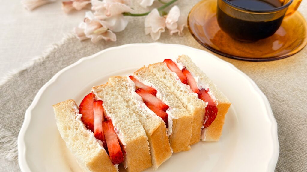 カルディ_「カルディオリジナル いちごホイップクリーム」を塗ったパンにいちごをサンドしている様子