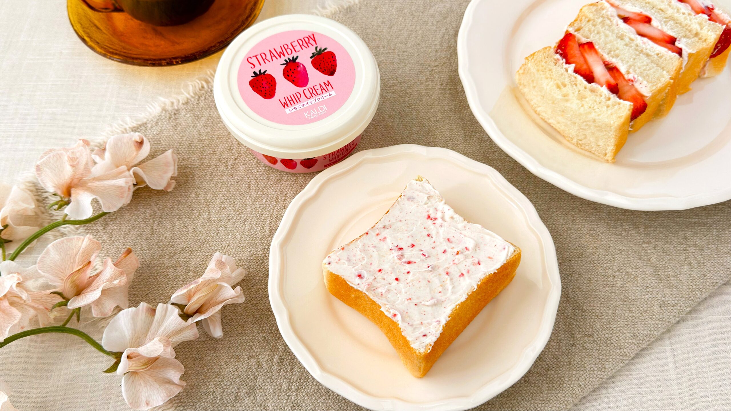 カルディ_「カルディオリジナル いちごホイップクリーム」を塗ったパンやパッケージが並んでいる様子