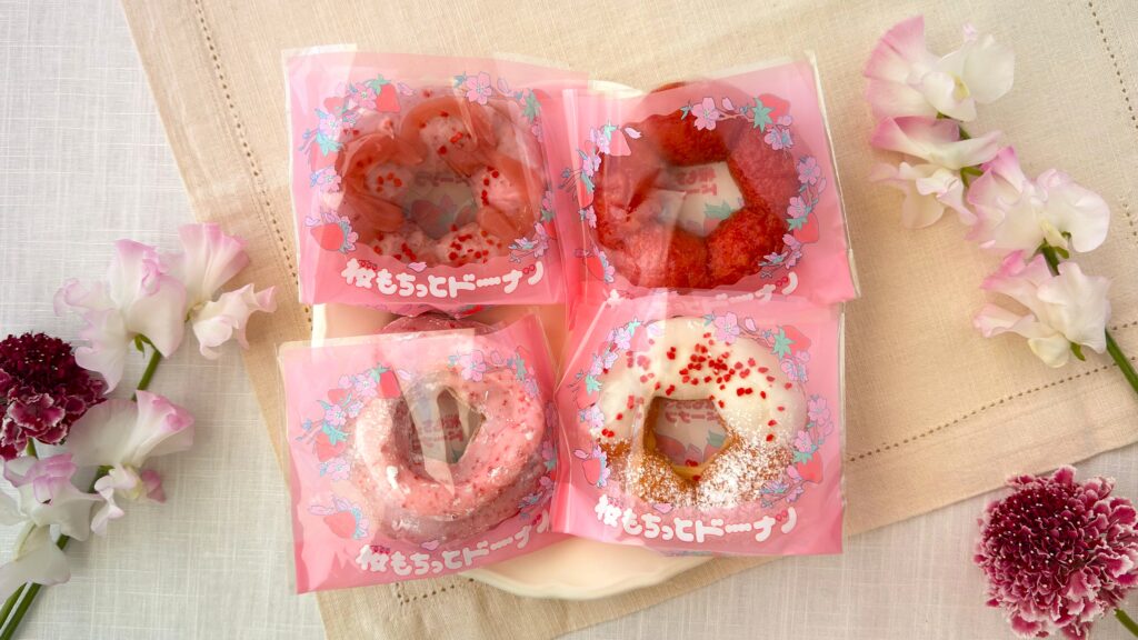 ミスタードーナツ_桜もちっとドーナツの「 春めくいちごホイップだいふく風」や「花やぐいちごみるくカスタード」「咲くいちごみるく」「春かおるいちご風」が皿にのっている様子