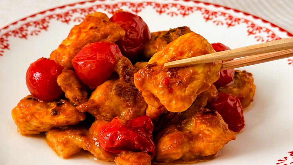 大塚食品_「メインディップ 鶏ももトマトのタンドリー」の鶏もも肉を箸で持っている様子