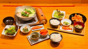 やまや_テーブルに並んだ「熟成鶏の唐揚げめんたい風味定食」と「やまや自慢のもつ鍋膳」