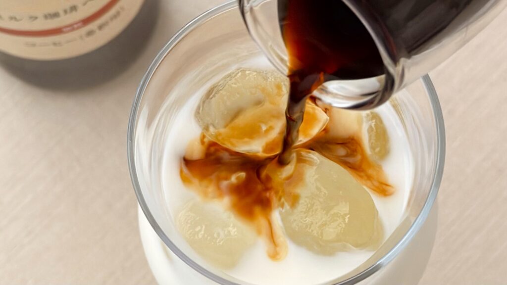 UCC_「加糖 上島珈琲店 ミルク珈琲ベース(希釈)瓶」をミルクに注いでいる様子