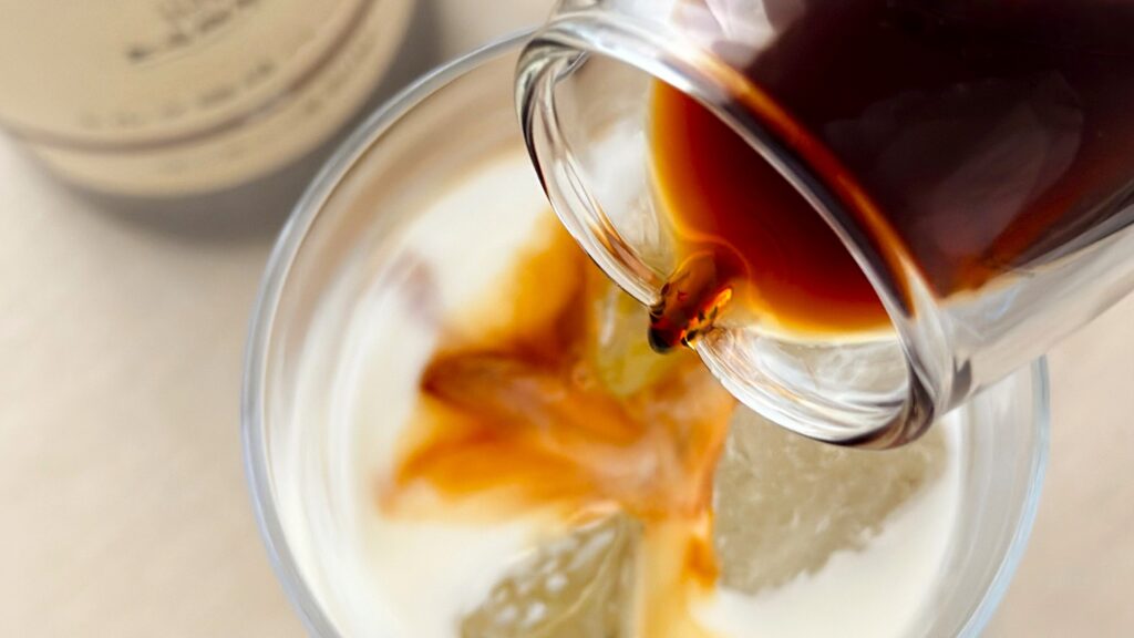 UCC_「無糖 上島珈琲店 ミルク珈琲ベース(希釈)瓶」をミルクに注いでいる様子