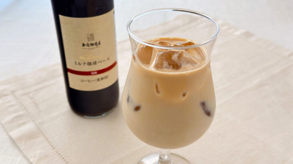 UCC_「加糖 上島珈琲店 ミルク珈琲ベース(希釈)瓶」とコーヒーが並んでいる様子