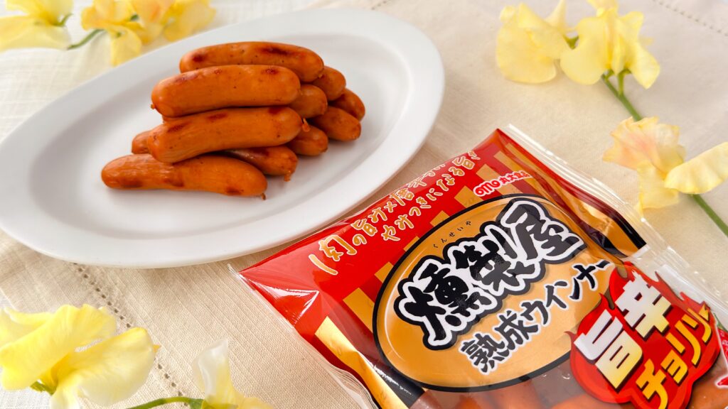 丸大食品_「燻製屋熟成ウインナー 旨辛チョリソー」のパッケージと皿盛り