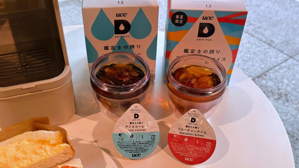 UCC_「鑑定士の誇り フルーティーアイス」と「鑑定士の誇り アイスコーヒー」のパッケージやカプセルが並んでいる様子