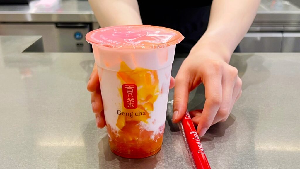 ゴンチャ_「ピーチフルピーチ ミルクティー」とストローをもらっている様子