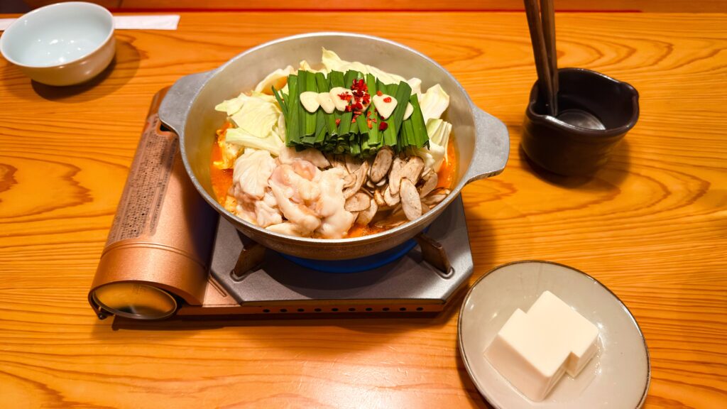 やまや_「旨辛もつ鍋」と豆腐が並んでいる様子