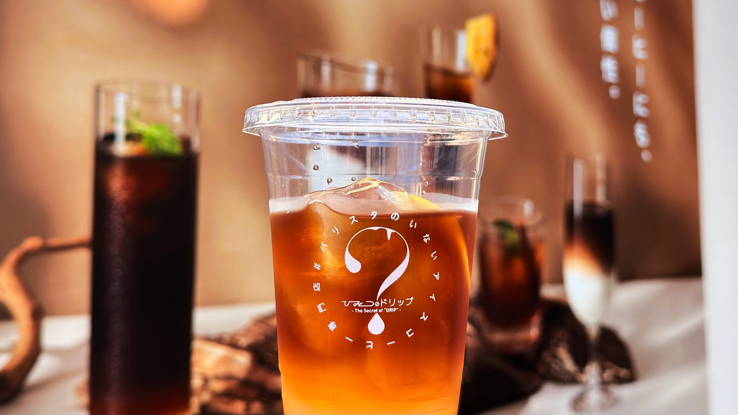 UCC_バリスタのいないアイスコーヒー専門店「ひみつのドリップ」の「コーヒーレモンスカッシュ(マイルド)」を持っている様子