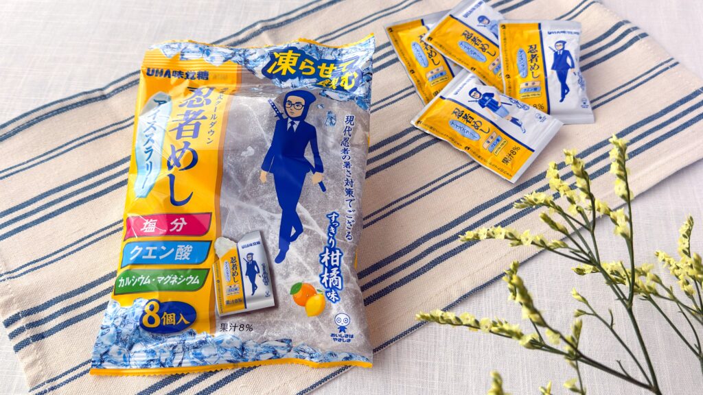 UHA味覚糖_テーブルの上に並んだ「忍者めしアイススラリー すっきり柑橘味」の個包装とパッケージ
