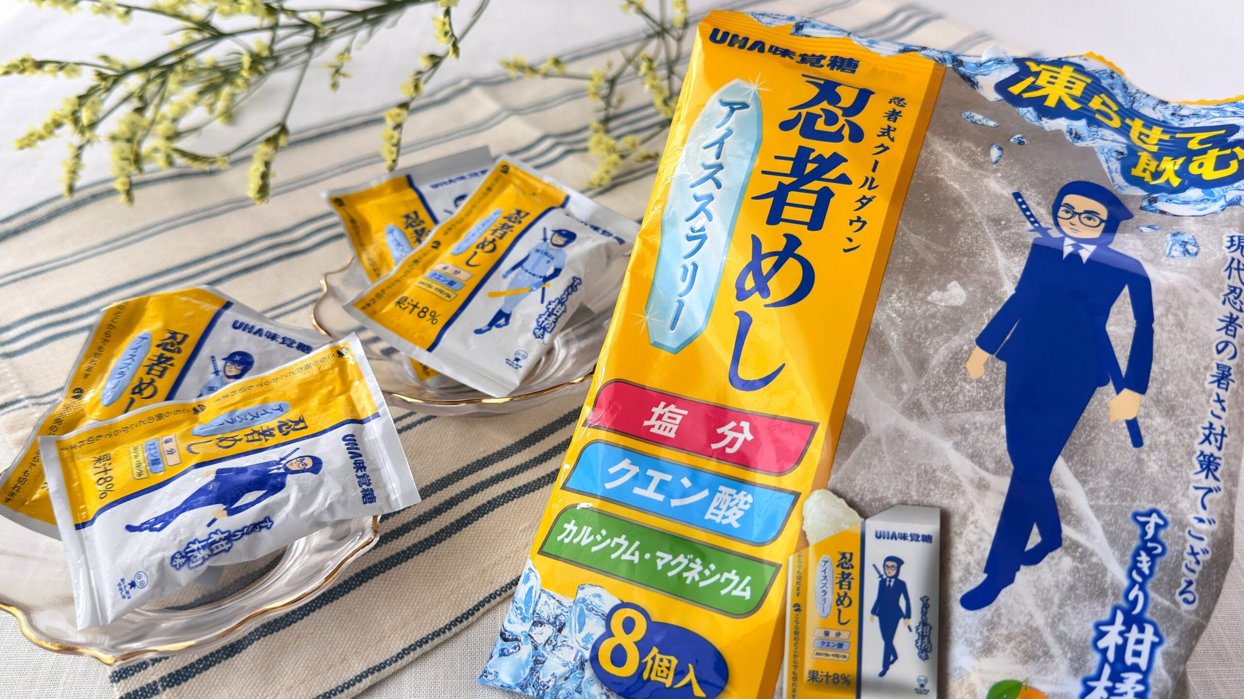 UHA味覚糖_「忍者めしアイススラリー すっきり柑橘味」のパッケージと個包装が並んでいる様子