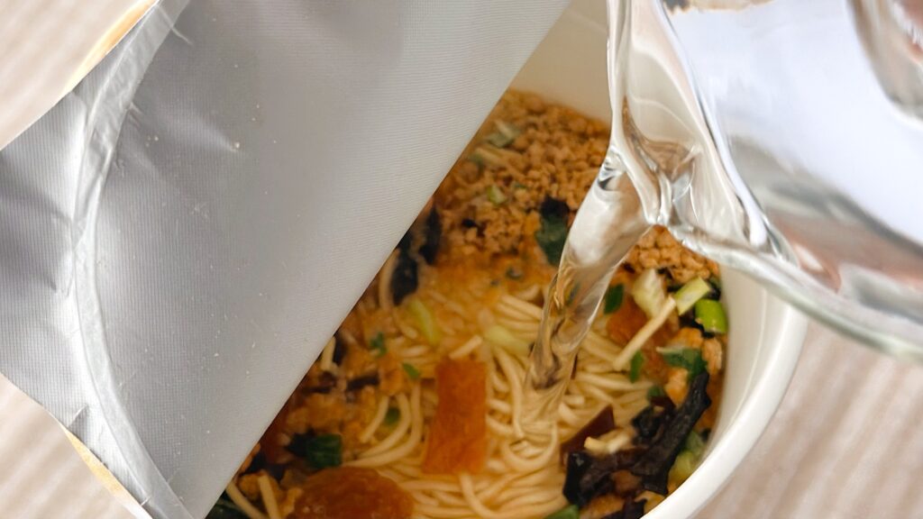 渡辺製麺_「博多豚骨ラーメン 一風堂白丸元味」にお湯を注いでいる様子