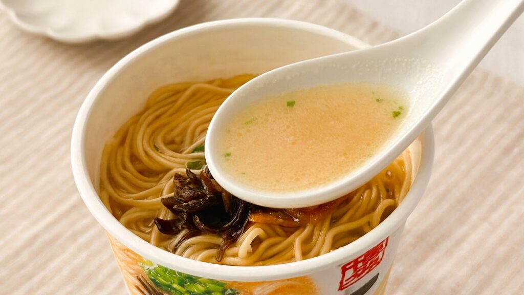 渡辺製麺_「博多豚骨ラーメン 一風堂白丸元味」のスープをレンゲですくっている様子