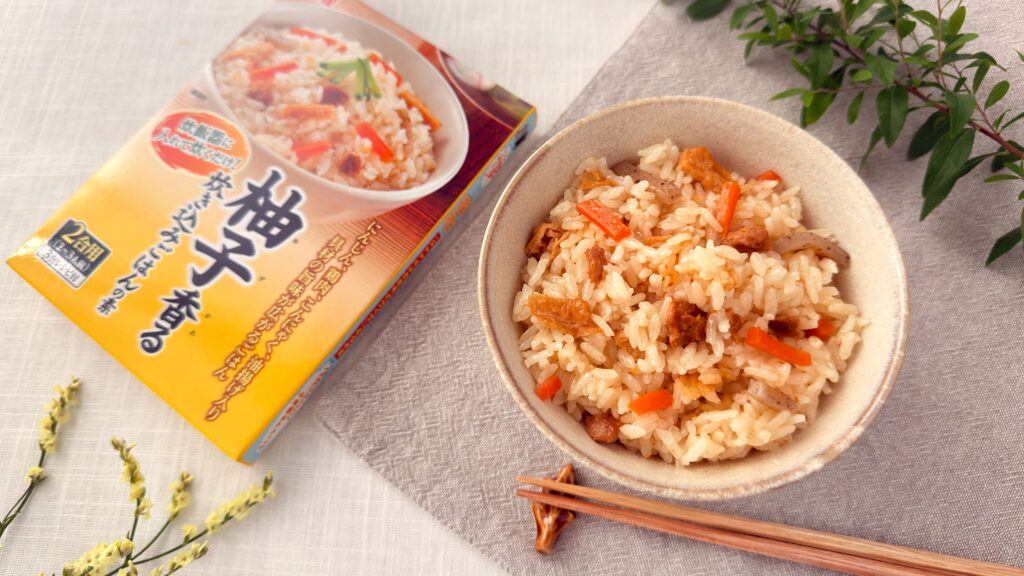 丸美屋_「柚子香る炊き込みごはんの素」で炊いたご飯とパッケージがテーブルの上にのっている様子