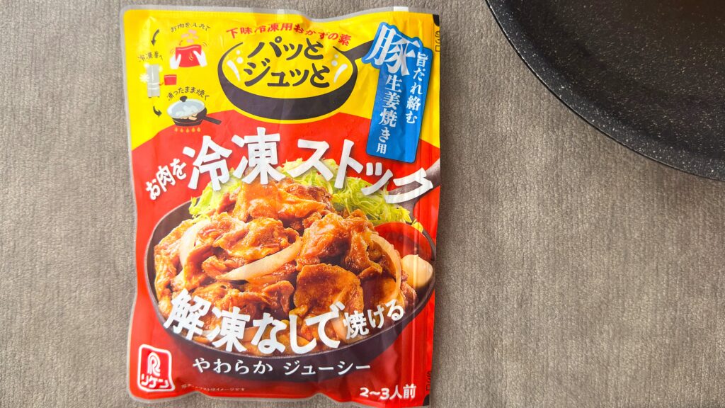 理研ビタミン_冷凍庫から取り出した「パッとジュッと® 旨だれ絡む豚生姜焼き用」のパッケージとフライパンが並んでいる様子