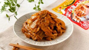 理研ビタミン_「パッとジュッと® 旨だれ絡む豚生姜焼き用」の皿盛りとパッケージ