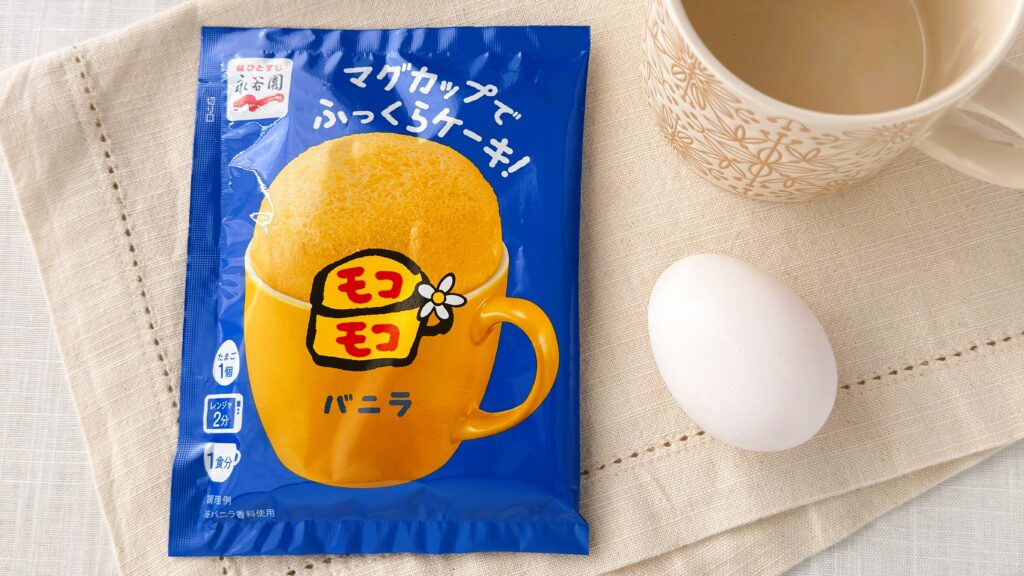 永谷園_「マグカップでふっくらケーキ！モコモコ バニラ」や卵、マグカップが置いてある様子