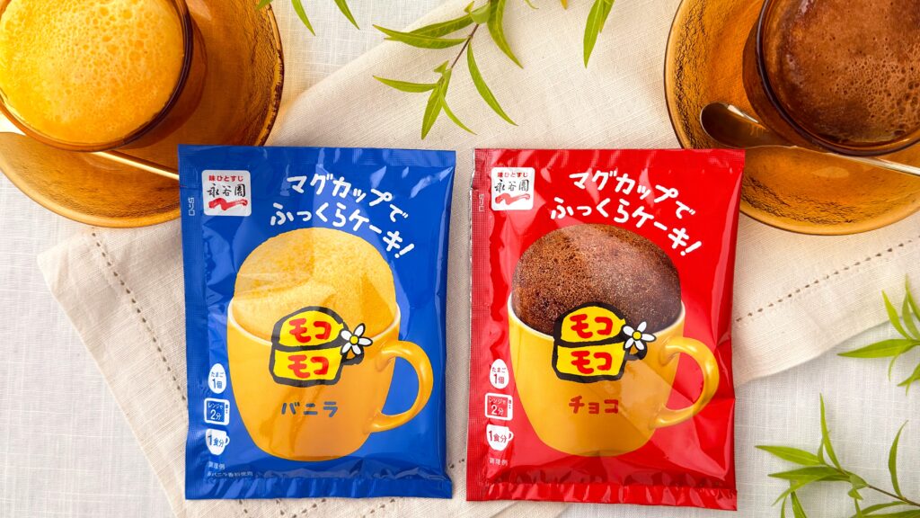 永谷園_テーブルの上に並んだ「マグカップでふっくらケーキ！モコモコ バニラ」と「マグカップでふっくらケーキ！モコモコ チョコ」