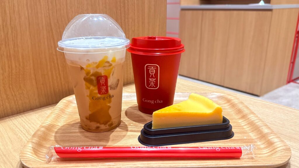 ゴンチャ_お盆にのった「紅はるか ミルクティー」のアイスとホット、ニューヨークチーズケーキ